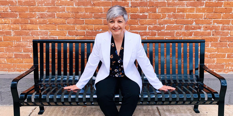 A woman sitting on top of a bench.